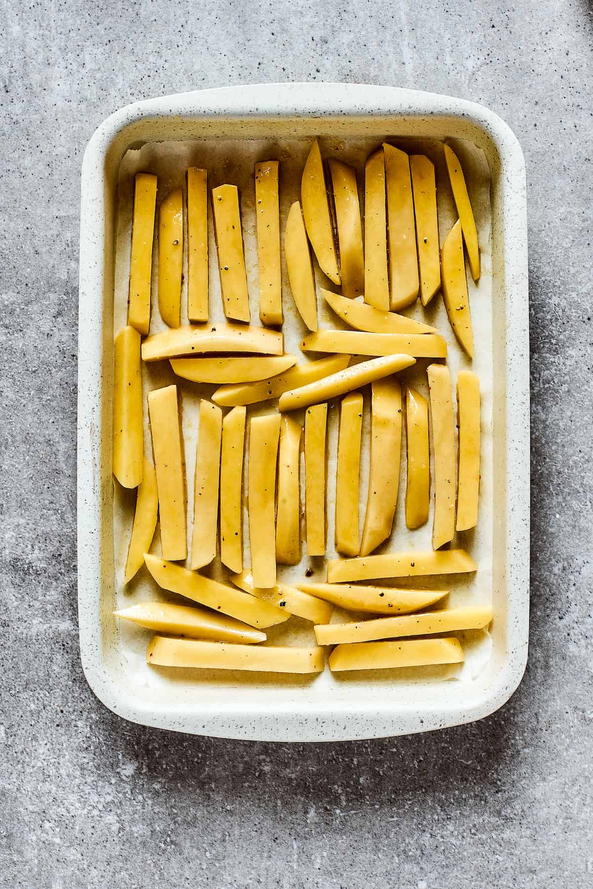 Crispy and flavorful, Truffle Fries may become your new favorite fry! They're touched with truffle salt and a dusting of parmesan cheese. Fries in a white baking dish.