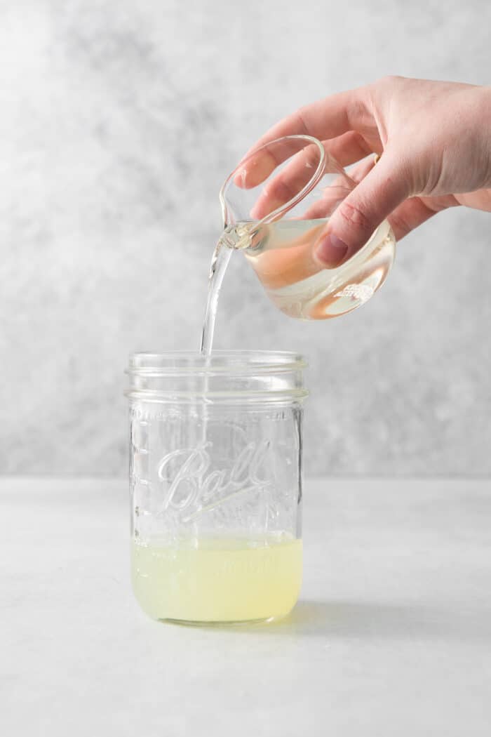This Classic Daiquiri is an easy and refreshing cocktail you can make with just three ingredients. The perfect balance of sweet and tart! Lime juice being poured into a mason jar