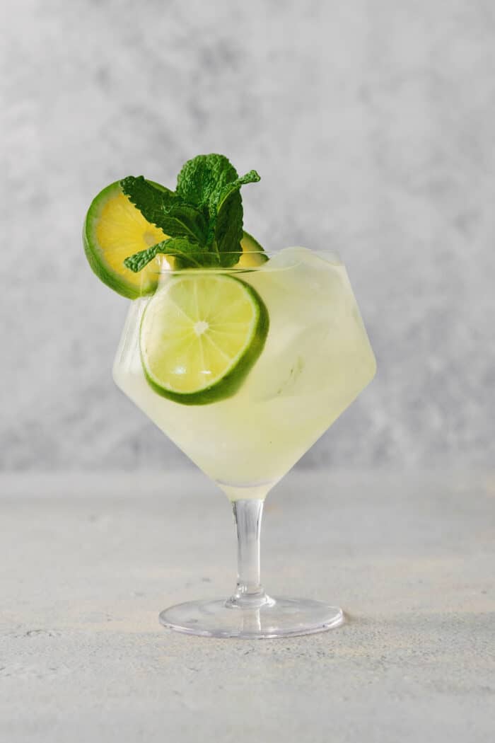 Crisp and refreshing, a Classic Mojito is the only mojito recipe you truly need! Lime juice, mint, and rum make this wonderful cocktail. A mojito is shown in a glass topped with mint and lime.