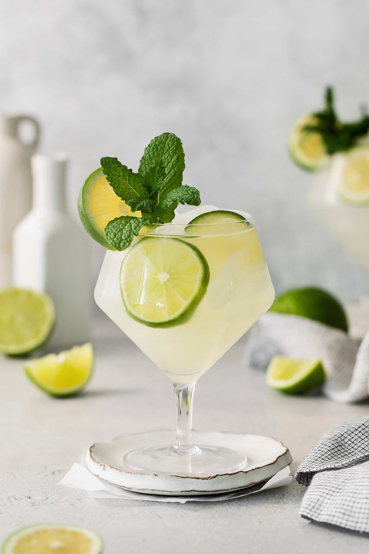 Classic mojitos are shown in glasses topped with mint and lime.