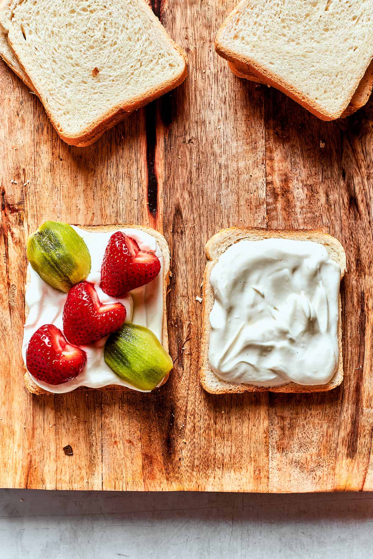 Fruit sandos are assembled with cream filling and fruit on white bread
