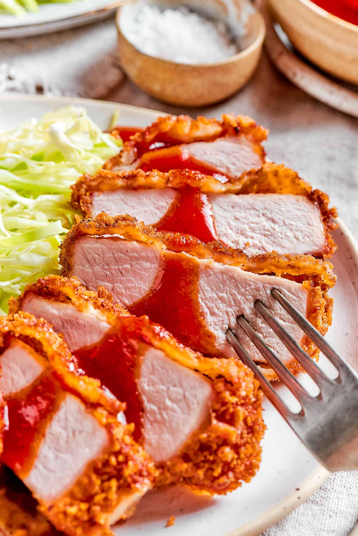 Tender, juicy Pork Katsu is always welcome on my dinner table! This Japanese dish deep fries breaded pork loin until crispy. Slices of pork katsu with shredded cabbage.