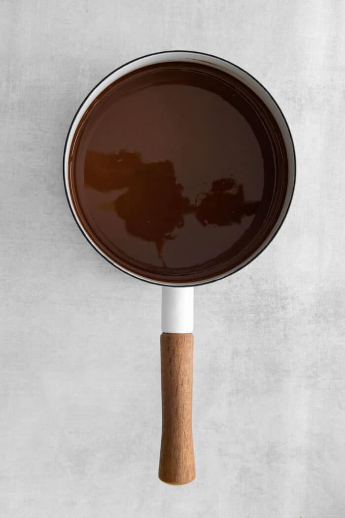 This is the easiest and best Chocolate Magic Shell recipe! Just 3 ingredients melt together to make an amazing topping. A pot of melted magic shell.