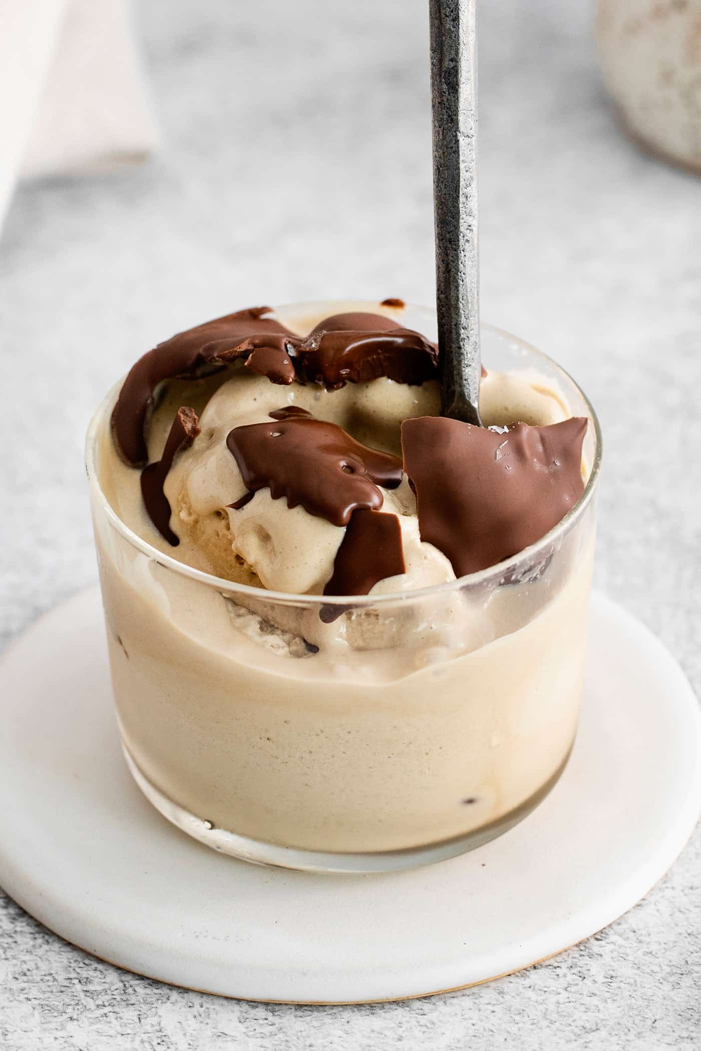 This is the easiest and best Chocolate Magic Shell recipe! Just 3 ingredients melt together to make an amazing topping. A bowl of ice cream topped with magic shell and a spoon.