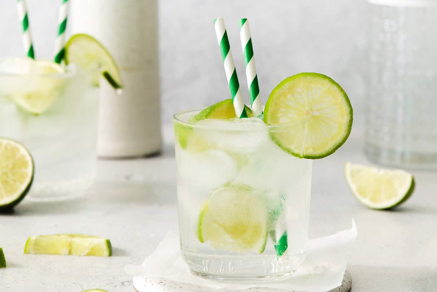 A Classic Gin and Tonic is a must to master. This recipe is for a super simple, super refreshing, and always-in-style cocktail. Glasses of gin and tonic with and lime circles and wedges.