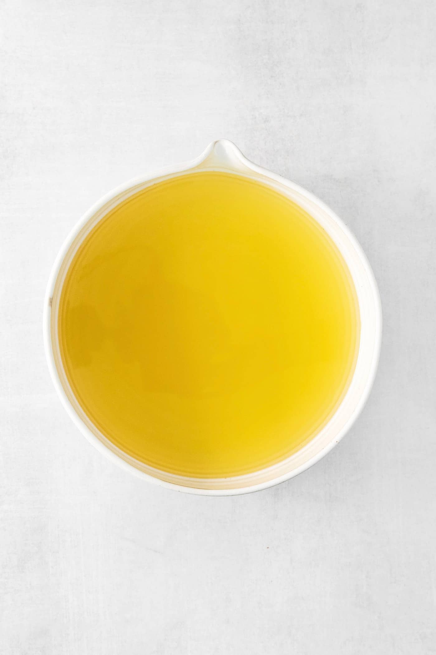 A small glass of this homemade Limoncello, served straight from the freezer, is the loveliest end to a meal. A bowl of strained limoncello.