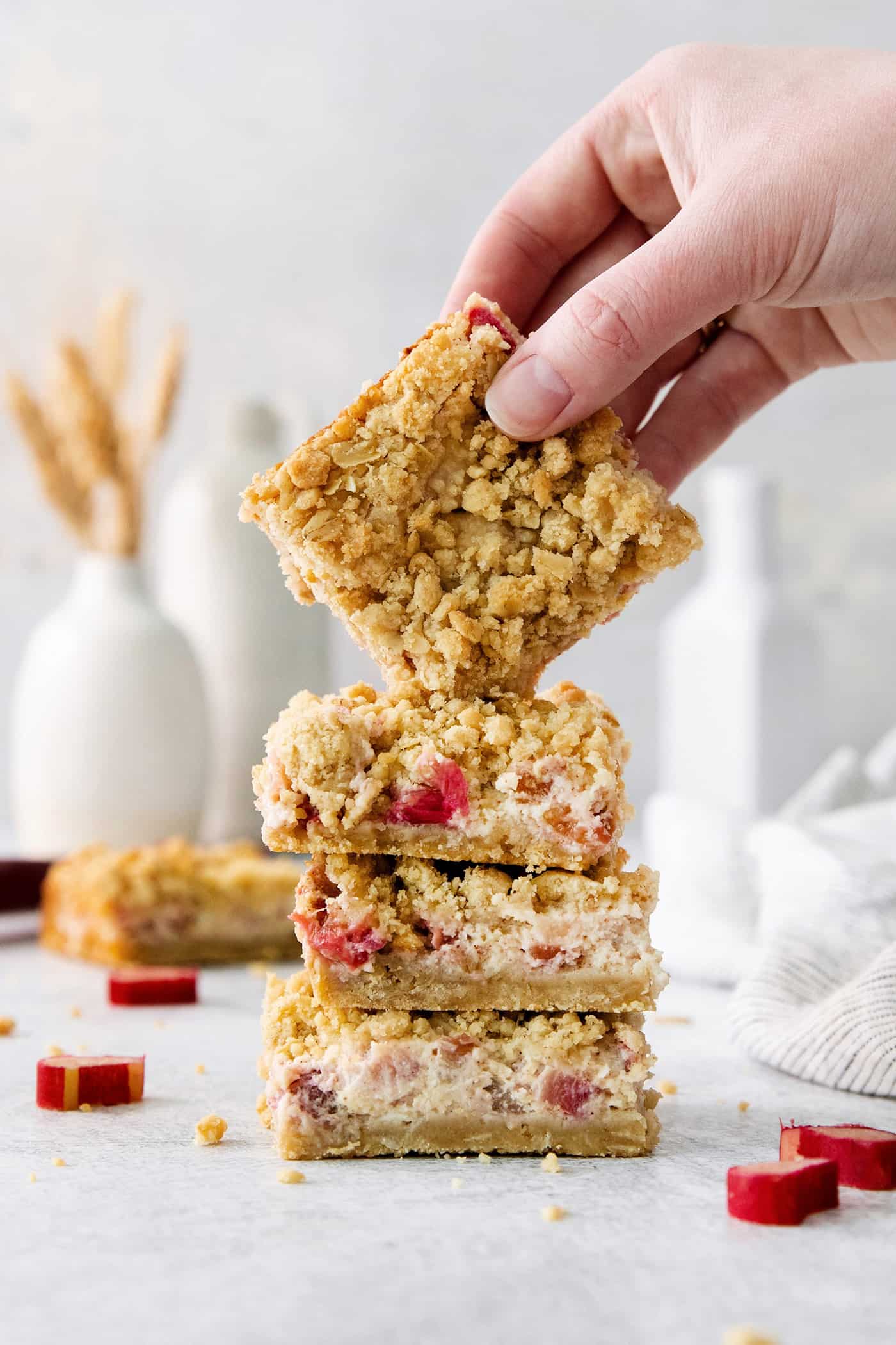 A hand lifts a rhubarb bar.