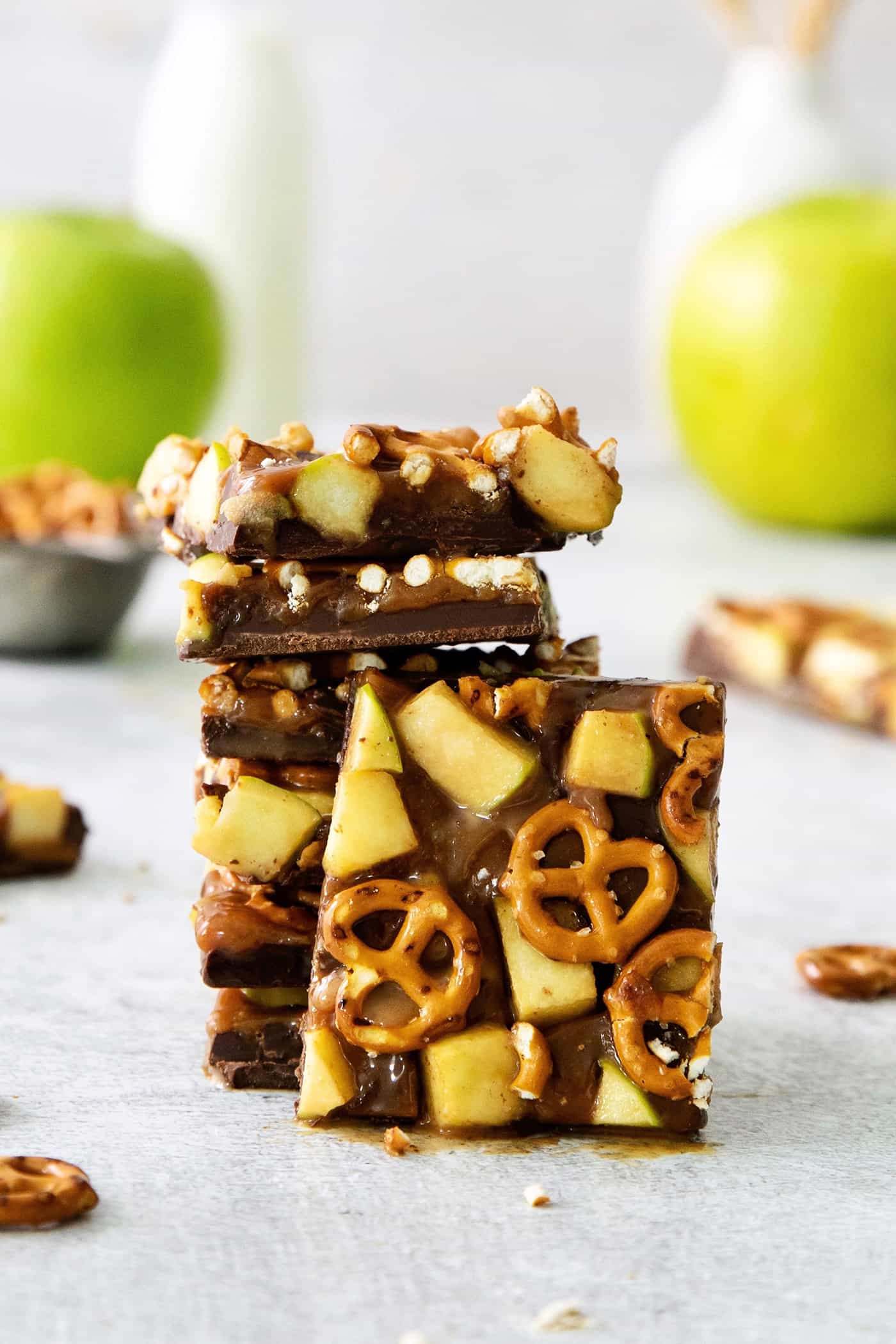 This Caramel Apple Bark is a fun treat to make when you want the flavor of a fresh caramel apple without the hassle. A close up of pieces of caramel apple bark with pretzels stacked on top of each other.
