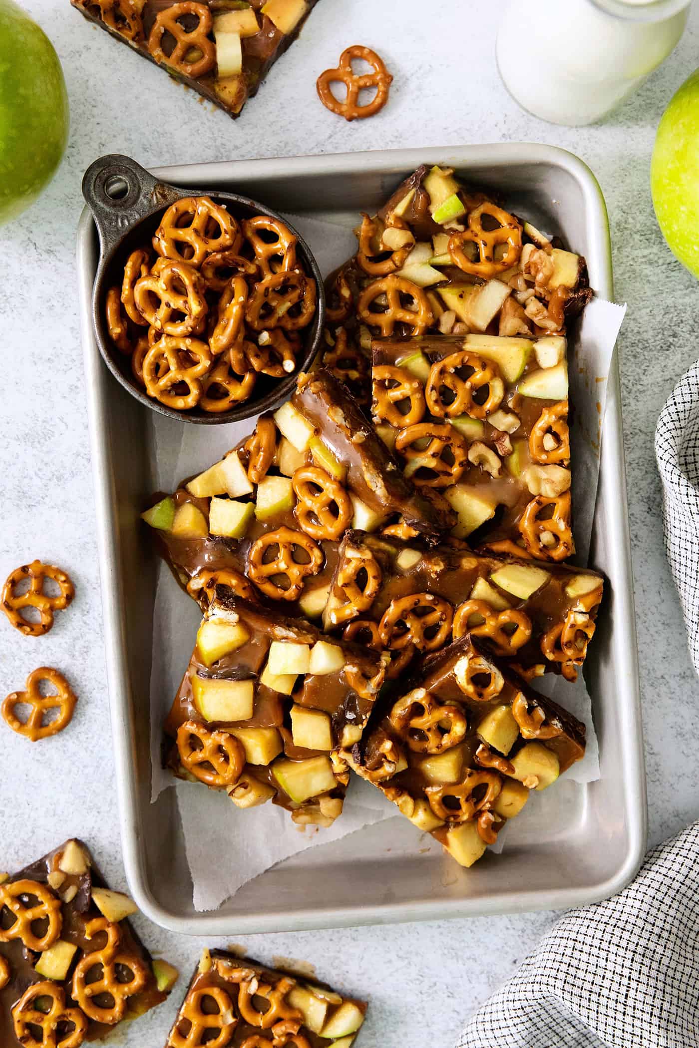 This Caramel Apple Bark is a fun treat to make when you want the flavor of a fresh caramel apple without the hassle. Cut up pieces of caramel apple bark are seen on a baking tray.