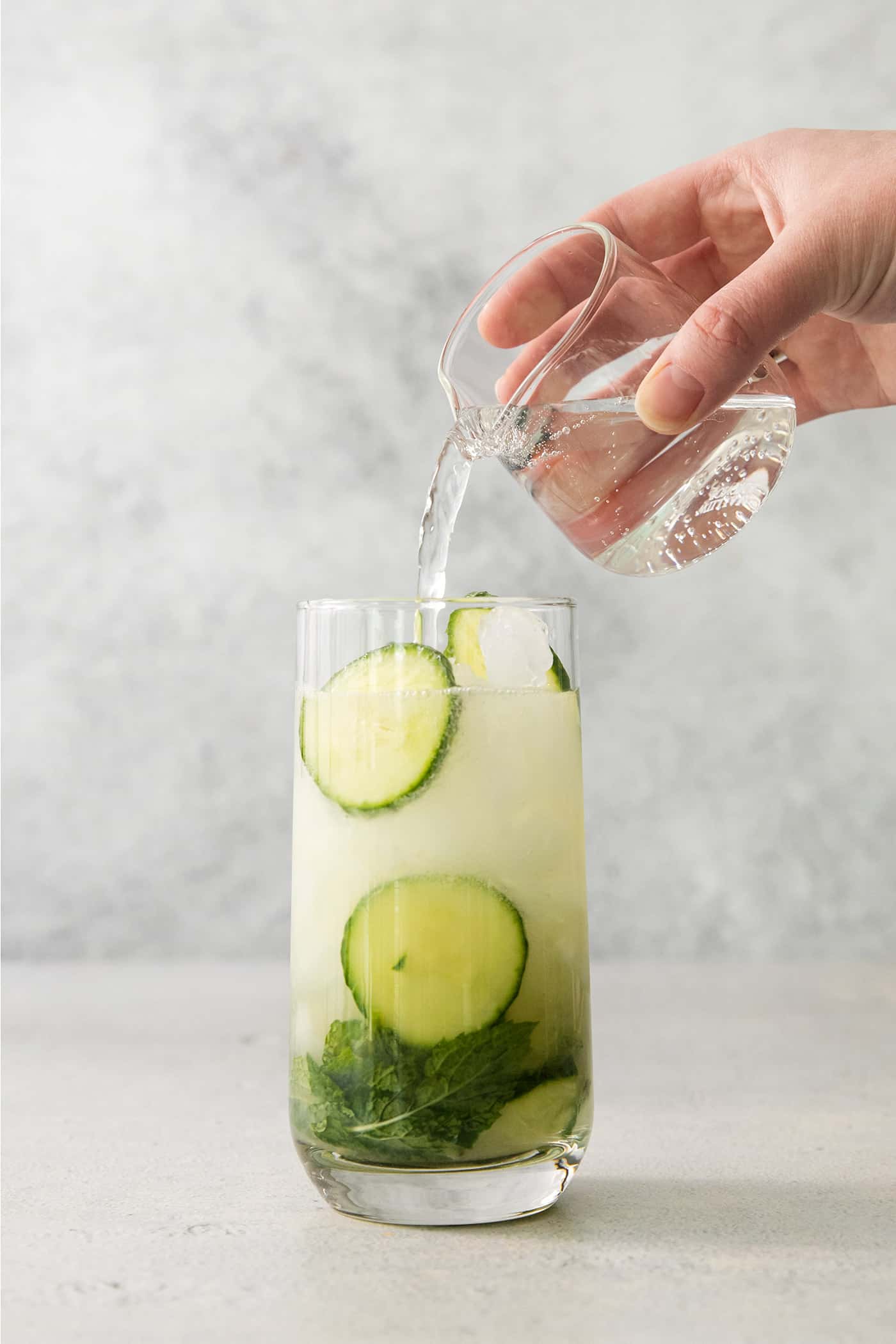 A Cucumber Mojito takes your classic mojito recipe and adds orange liqueur and cucumber slices for a refreshing twist on a minty favorite. Topping a cucumber mojito with club soda.