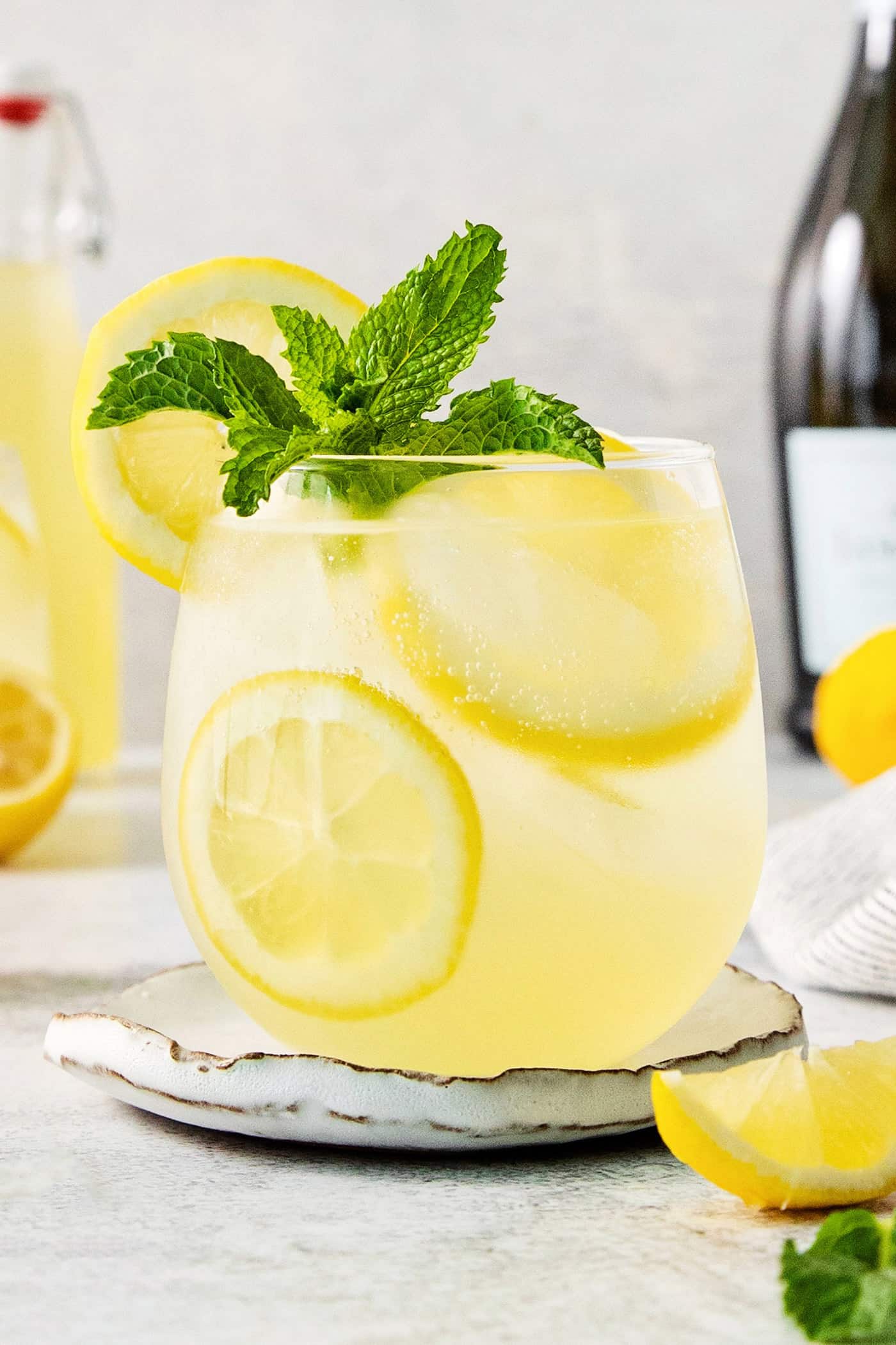 This Limoncello Spritz is fruity and refreshing, lightly sweet, and has a fun effervescence. It’s the perfect summer drink! A glass of limoncello spritz garnished with mint.