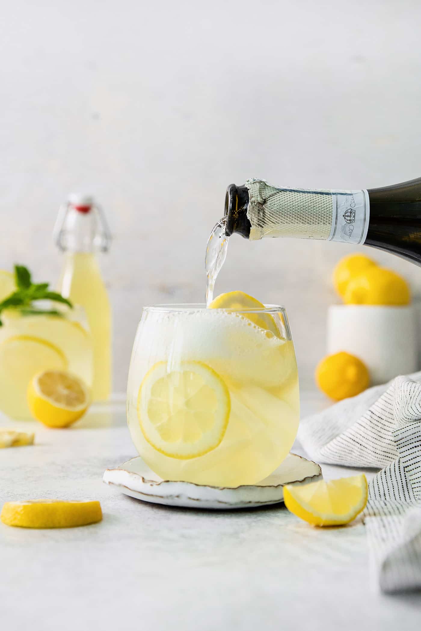 This Limoncello Spritz is fruity and refreshing, lightly sweet, and has a fun effervescence. It’s the perfect summer drink! A bottle of prosecco is poured into a limoncello spritz.