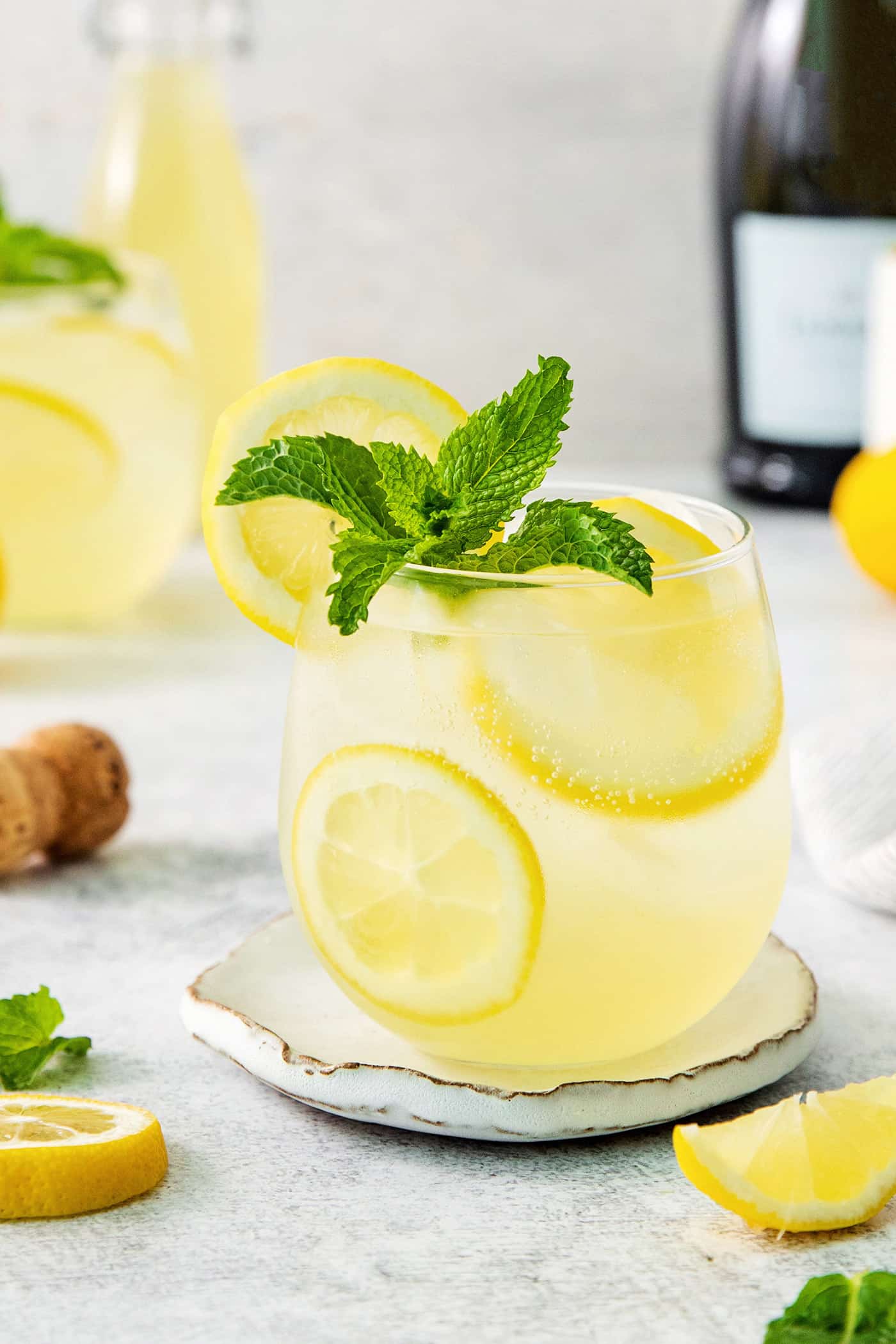 This Limoncello Spritz is fruity and refreshing, lightly sweet, and has a fun effervescence. It’s the perfect summer drink! A glass of limoncello spritz garnished with mint.