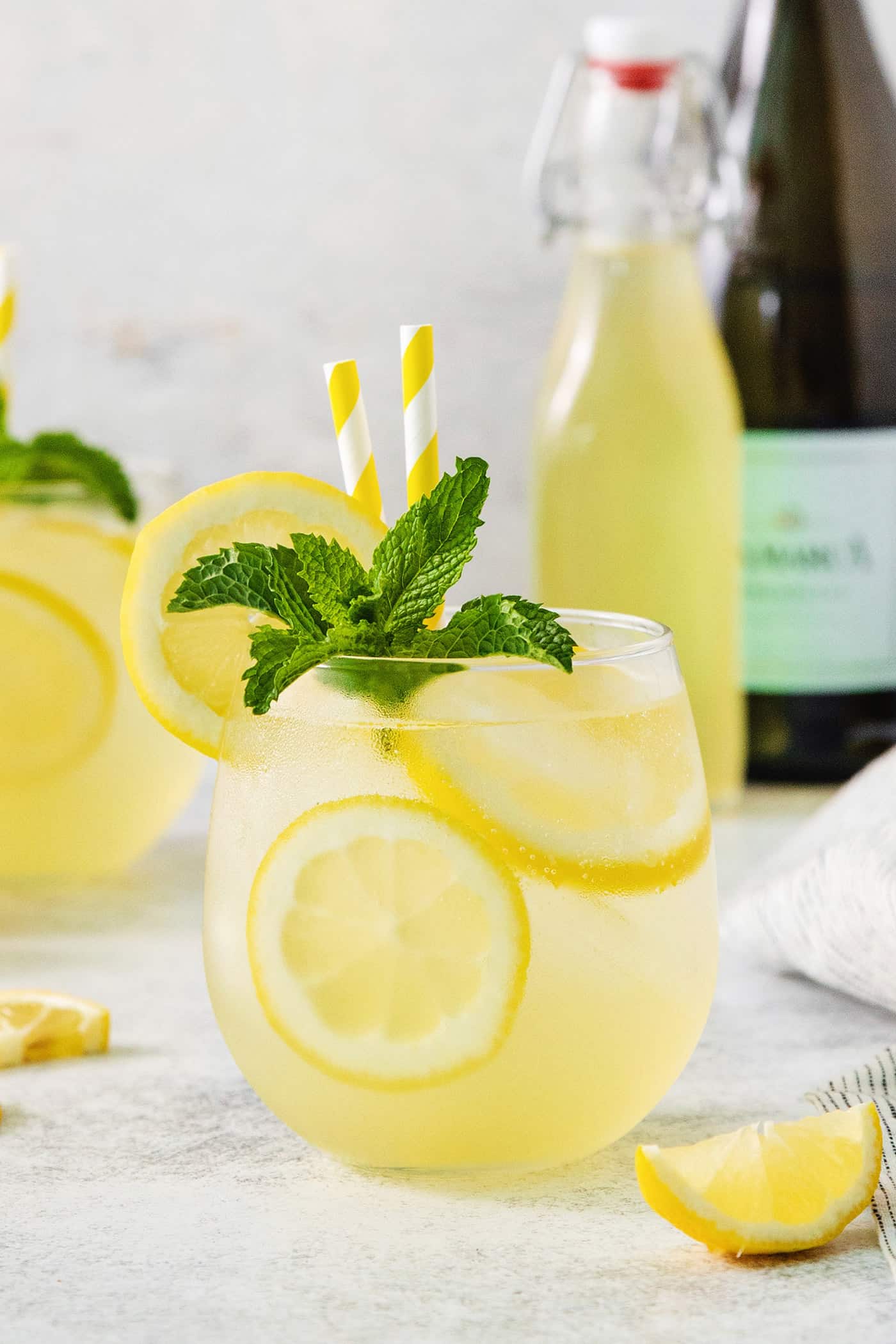 This Limoncello Spritz is fruity and refreshing, lightly sweet, and has a fun effervescence. It’s the perfect summer drink! A glass of limoncello spritz garnished with mint.