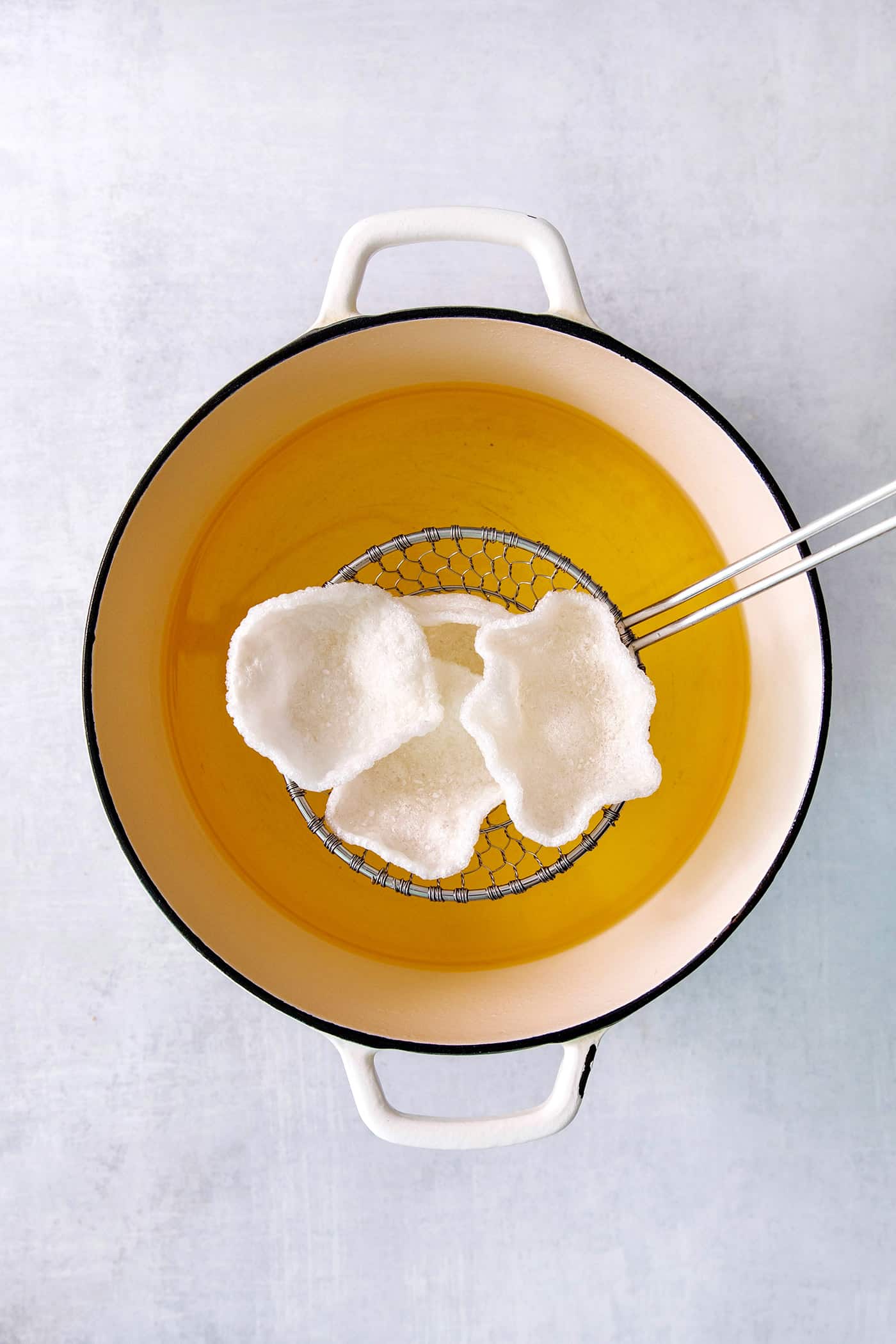 Shrimp Chips are a quick snack that will satisfy your craving for something with a salty crunch and a light umami flavor. Prawn crackers are shown above a pot of hot oil.