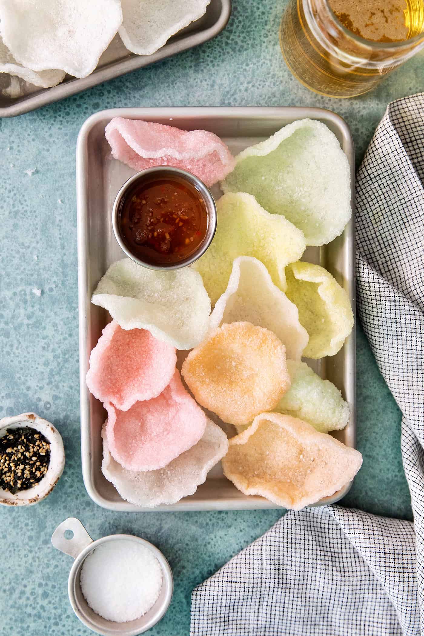 Shrimp Chips are a quick snack that will satisfy your craving for something with a salty crunch and a light umami flavor. A tray of multicolored shrimp chips and sauce.