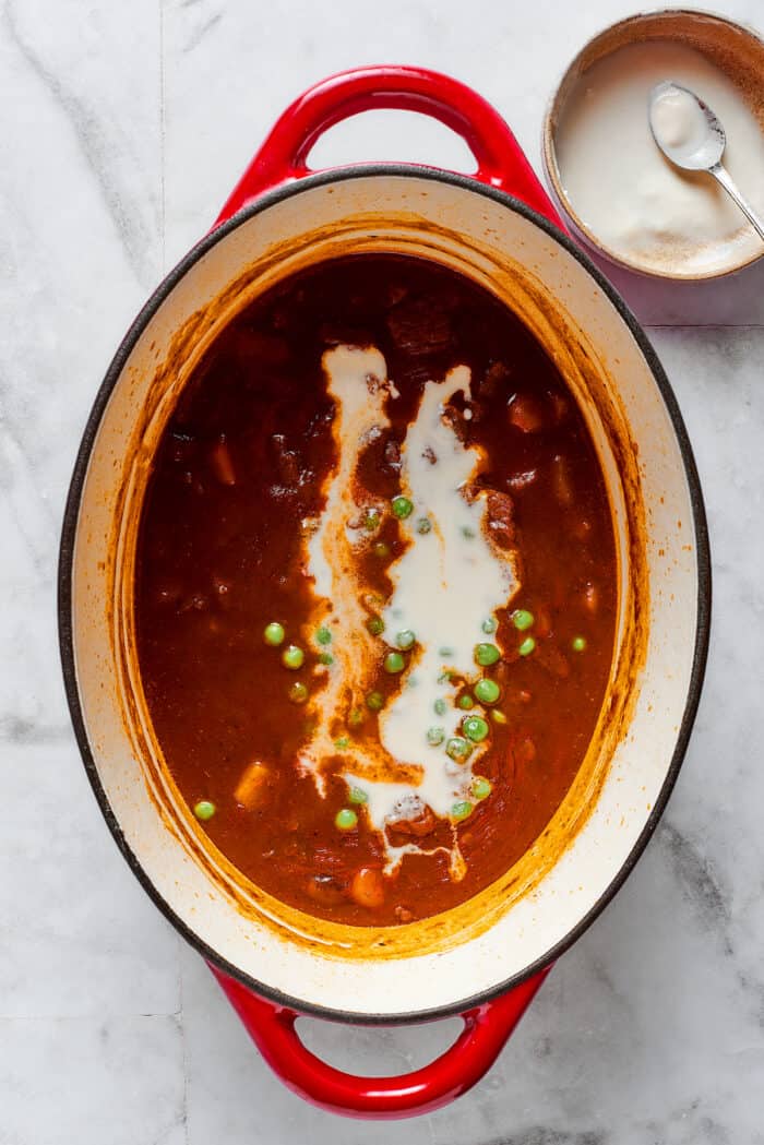 Comforting Beef Pot Pie is packed with tender beef and vegetables tucked into a stout-based gravy with flaky pie crust balanced on top. A flour slurry is added to pot pie filling to thicken it.