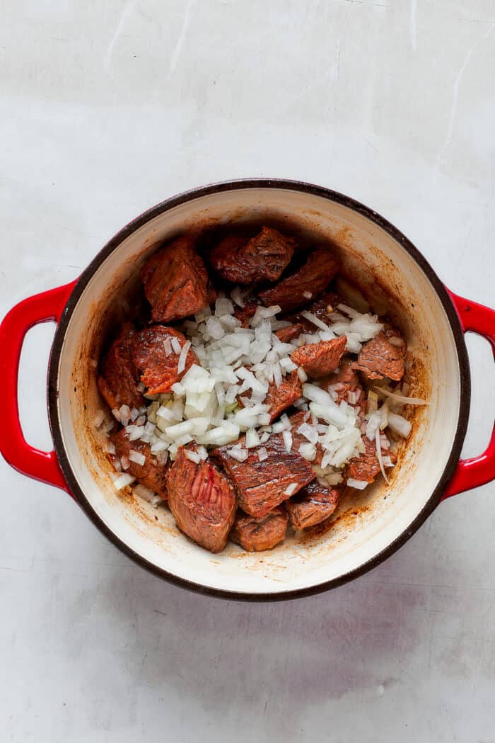 Comforting and rich Beef Pot Pie is packed with tender beef and vegetables tucked into a stout-based gravy with a wonderfully flaky pie crust balanced on top. You can enjoy this hearty meal the day of, or make it in advance and freeze it for dinner another time! Onion is sprinkled on top of meat for Mulligan stew.