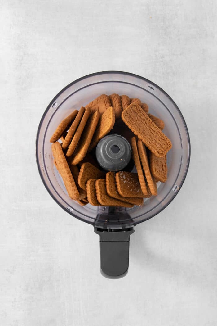 This Biscoff Cheesecake balances a rich cream cheese layer swirled with Biscoff cookie butter on a buttery cookie crust. A top down shot of biscoff cookies in a food processor.