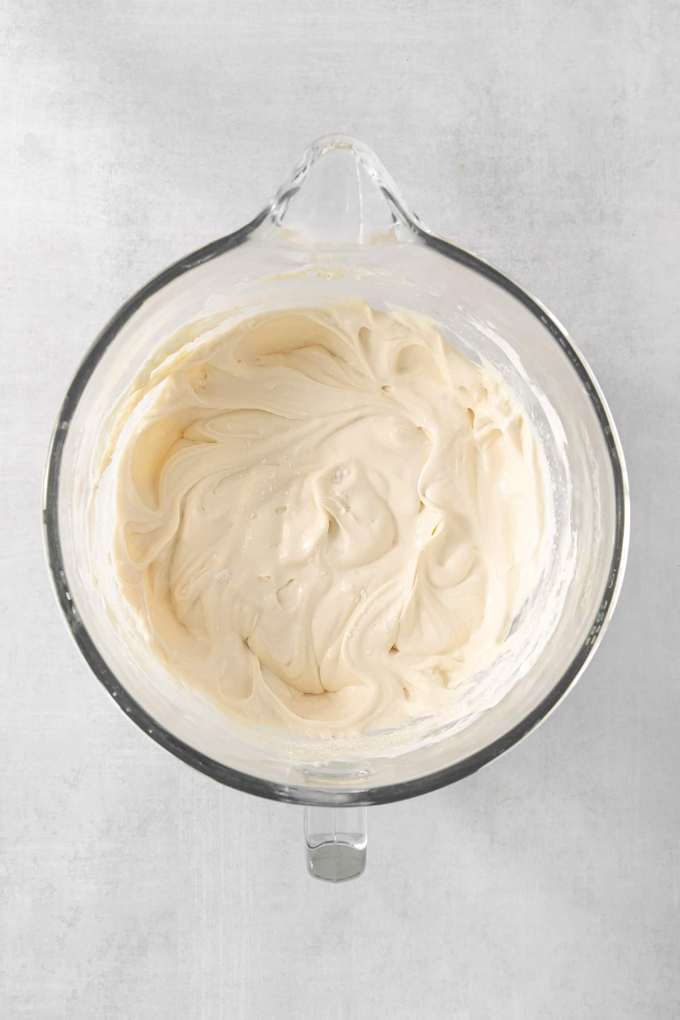 This Biscoff Cheesecake balances a rich cream cheese layer swirled with Biscoff cookie butter on a buttery cookie crust. A bowl of cheesecake batter.