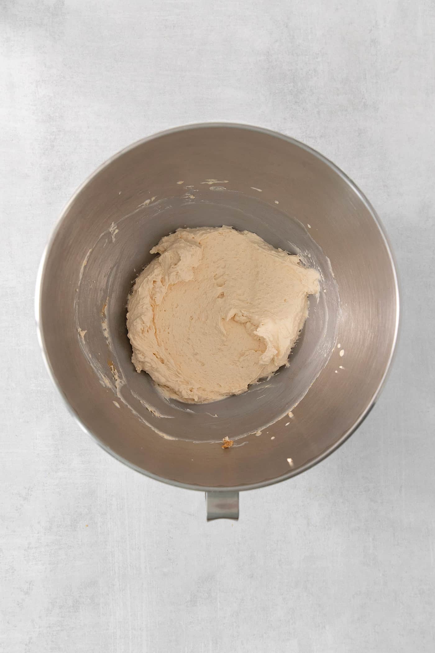 This Biscoff Cheesecake balances a rich cream cheese layer swirled with Biscoff cookie butter on a buttery cookie crust. Butterscotch whipped cream is shown in a metal bowl.