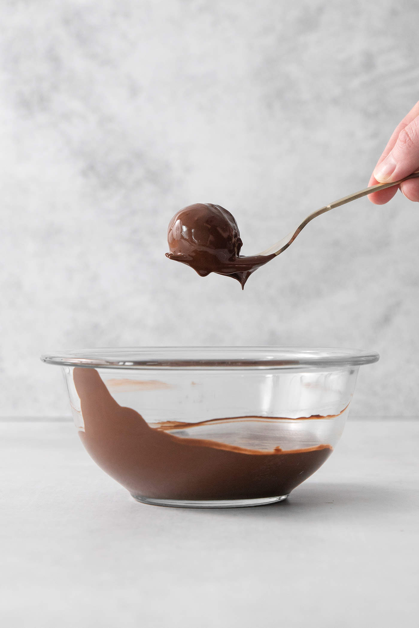 These Pumpkin Pie Truffles are the perfect fall treat! The truffle filling is made with crisp cookies, cream cheese, pumpkin puree, and spice. A fork holds a pumpkin pie truffle that has been dipped in dark chocolate.