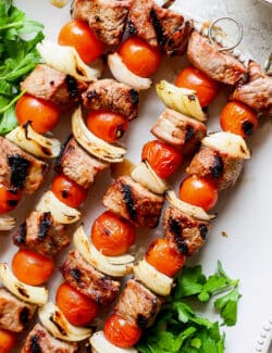Honey mustard beef kabobs are shown together on a white plate.
