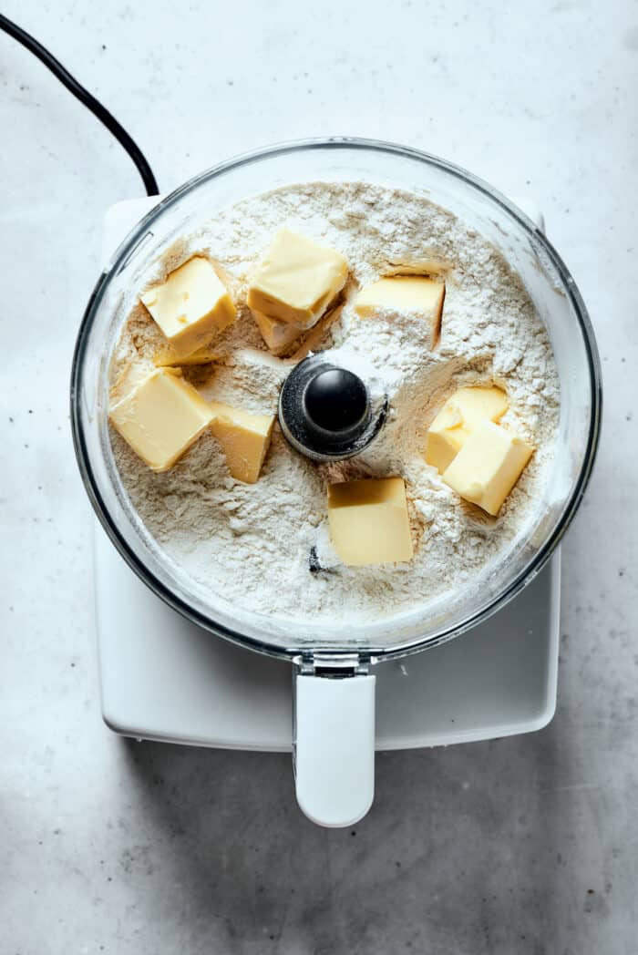 Napoleon Cake takes flaky homemade pastry and layers it with a sumptuous egg custard to make a creamy and cool dessert! Butter is added to a flour mix in a food processor.