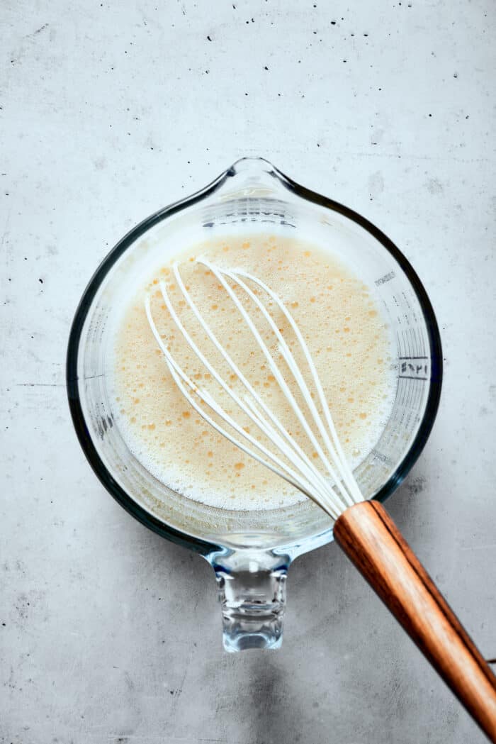 Napoleon Cake takes flaky homemade pastry and layers it with a sumptuous egg custard to make a creamy and cool dessert! Eggs are whisked in a glass measuring cup.