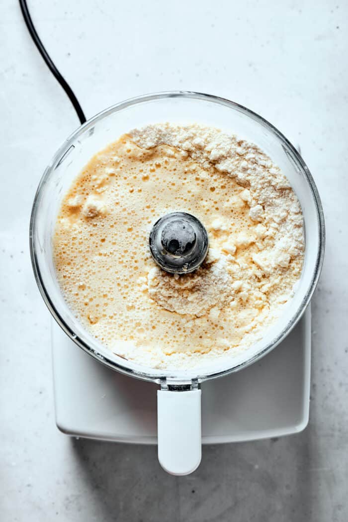 Napoleon Cake takes flaky homemade pastry and layers it with a sumptuous egg custard to make a creamy and cool dessert! Ingredients for pastry dough are shown in a food processor.