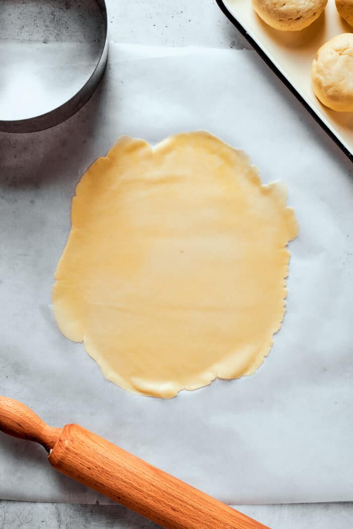 Napoleon Cake takes flaky homemade pastry and layers it with a sumptuous egg custard to make a creamy and cool dessert! A thin sheet of pastry dough on a white background.