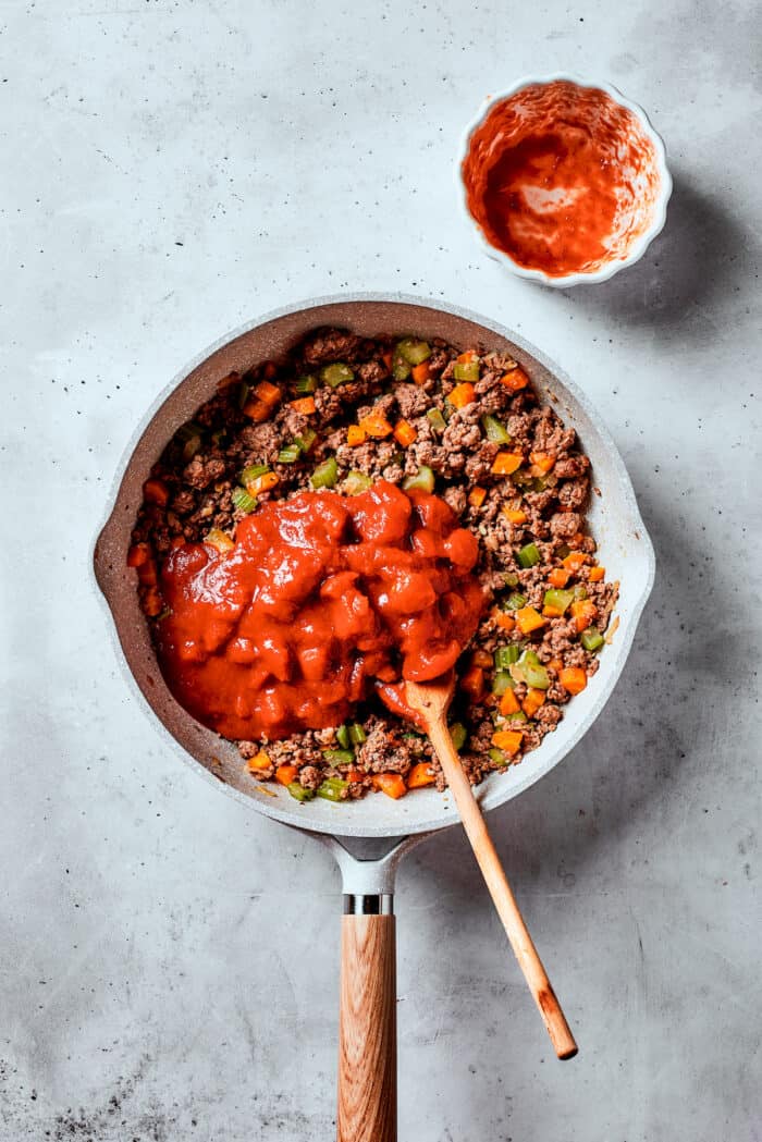 Easy, Italian-inspired Pasta Fazool is a wonderful soup that pairs creamy white beans with ground meat and pasta in a tomato-based broth. Diced tomatoes are added to a skillet f meat and vegetables.