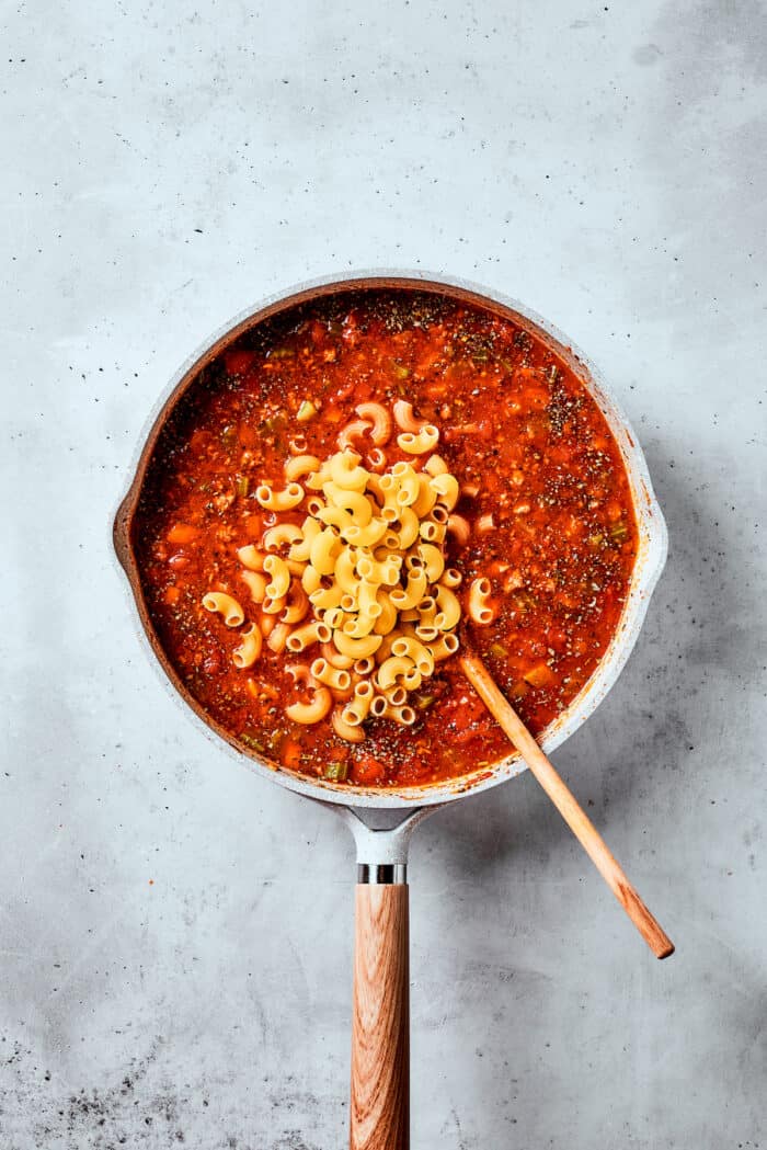Easy, Italian-inspired Pasta Fazool is a wonderful soup that pairs creamy white beans with ground meat and pasta in a tomato-based broth. Pasta is shown on top of a pot of pasta fazool.