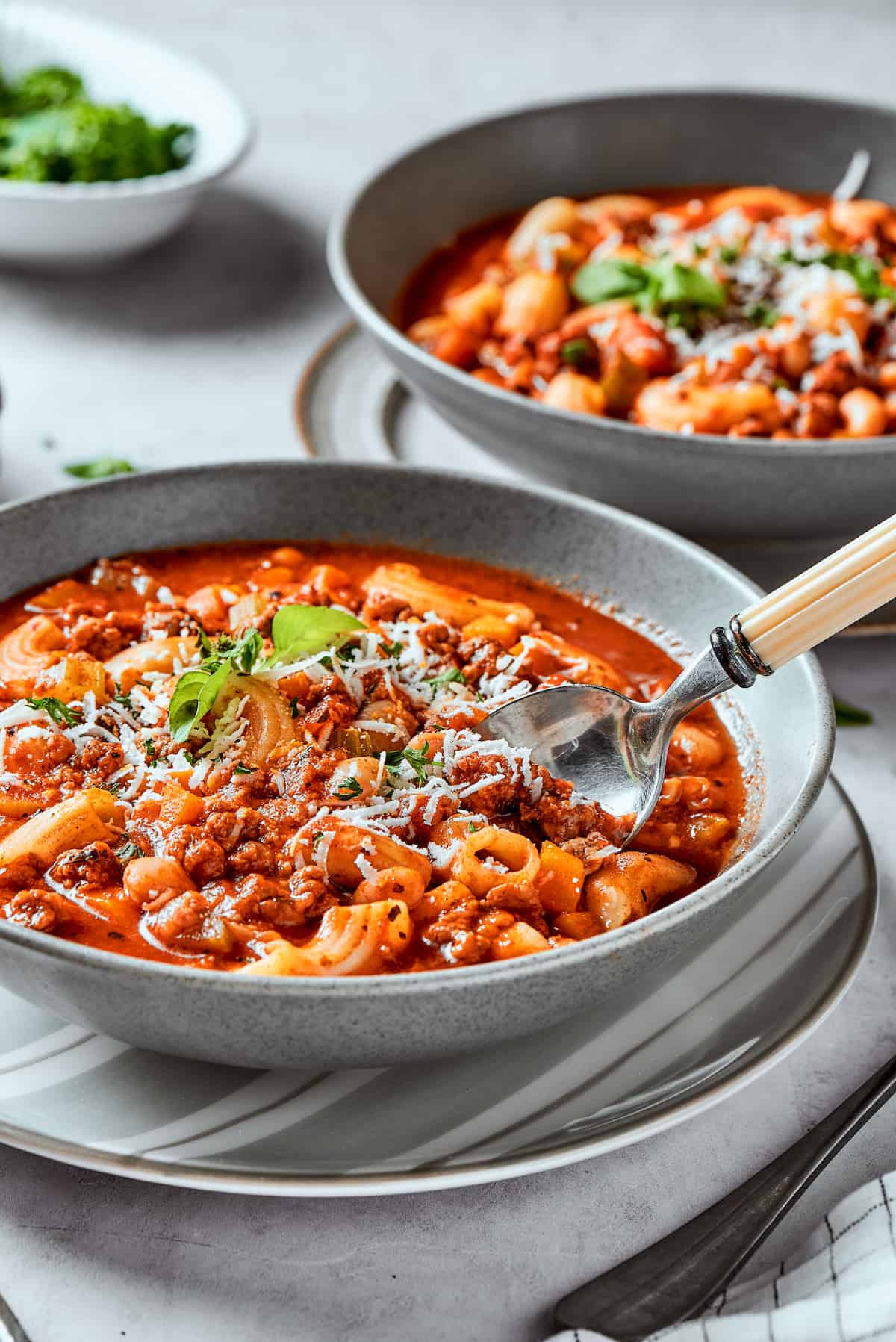 Easy, Italian-inspired Pasta Fazool is a wonderful soup that pairs creamy white beans with ground meat and pasta in a tomato-based broth. Bowls of pasta fazool on a table.