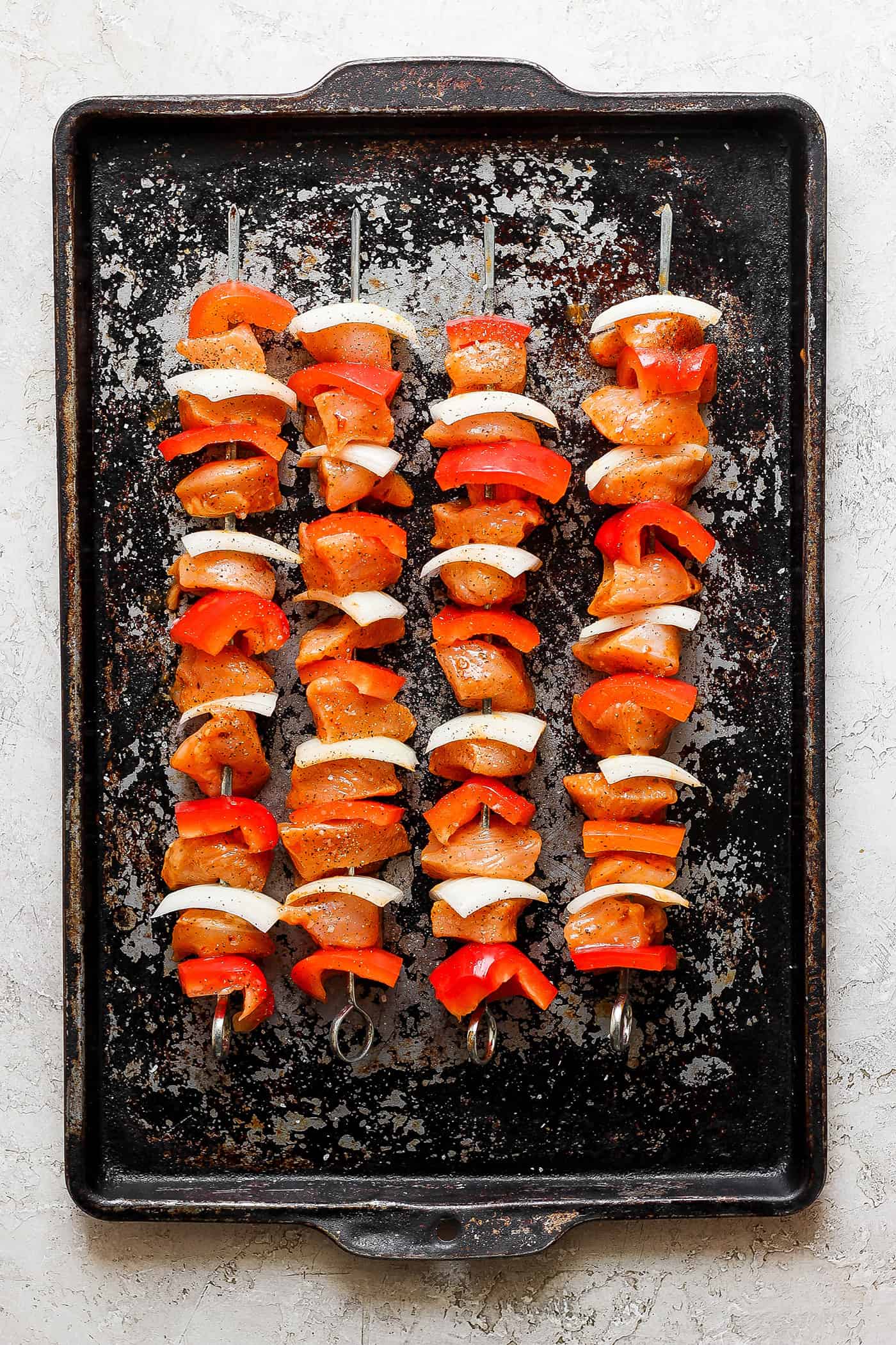 Sweet-spicy Chipotle Honey Chicken Kabobs bathe tender chicken in a honey-infused vinaigrette with a kick of spice. Chipotle honey chicken skewers are shown cooking on the grill.
