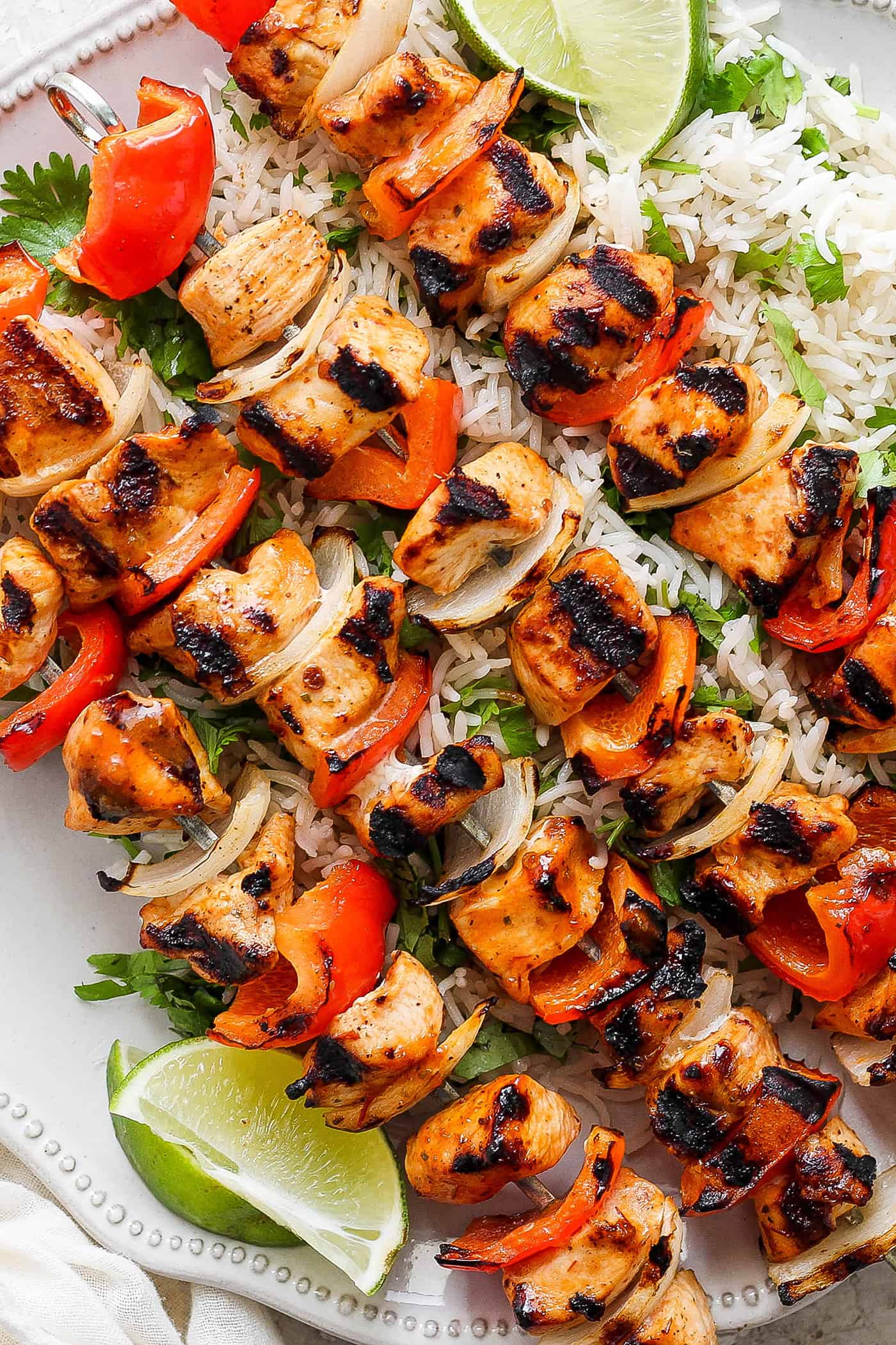 Sweet-spicy Chipotle Honey Chicken Kabobs bathe tender chicken in a honey-infused vinaigrette with a kick of spice. A close up shot of chipotle honey chicken kabobs with rice.
