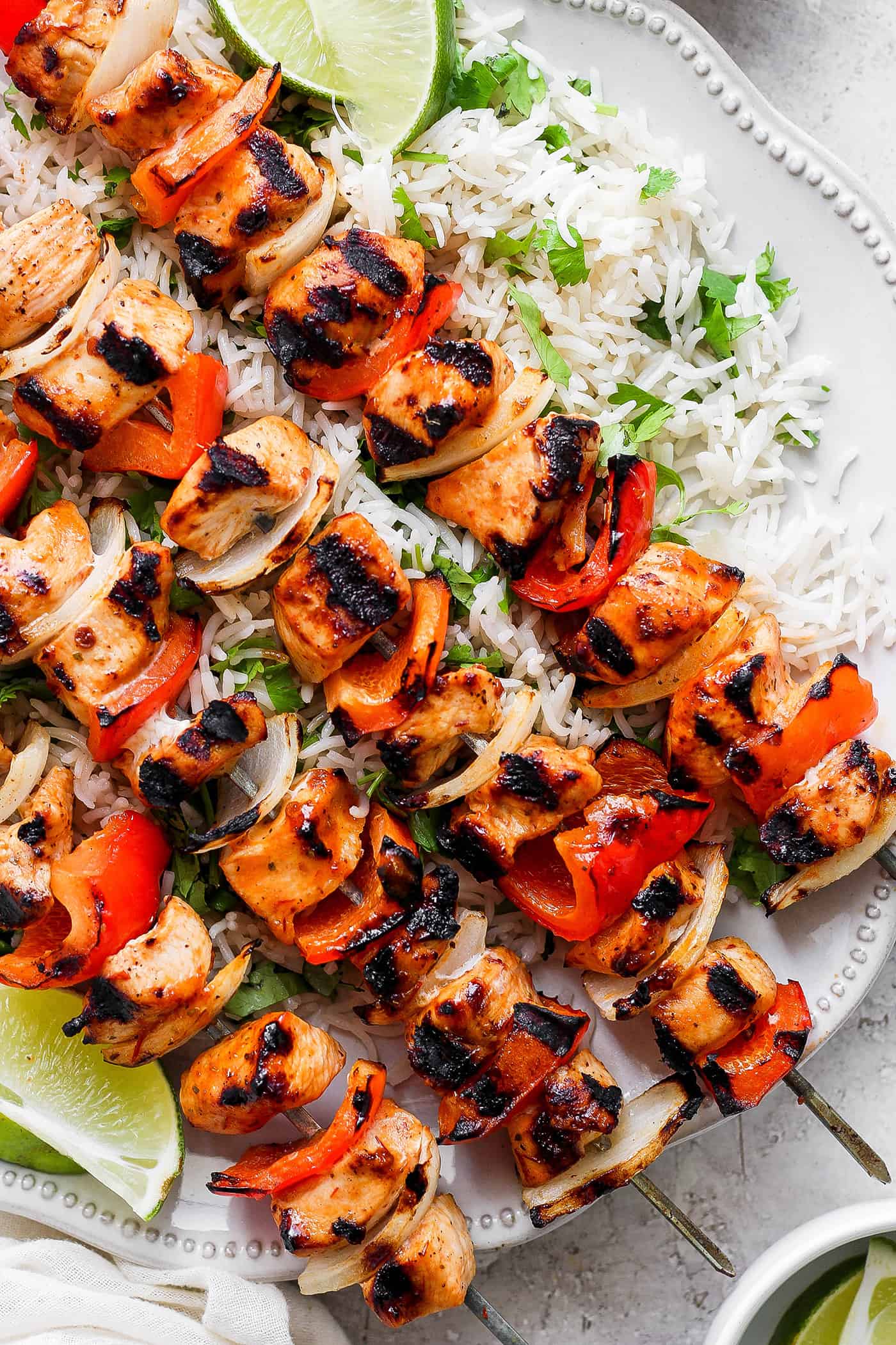 Sweet-spicy Chipotle Honey Chicken Kabobs bathe tender chicken in a honey-infused vinaigrette with a kick of spice. A close up shot of chipotle honey chicken kabobs with rice.