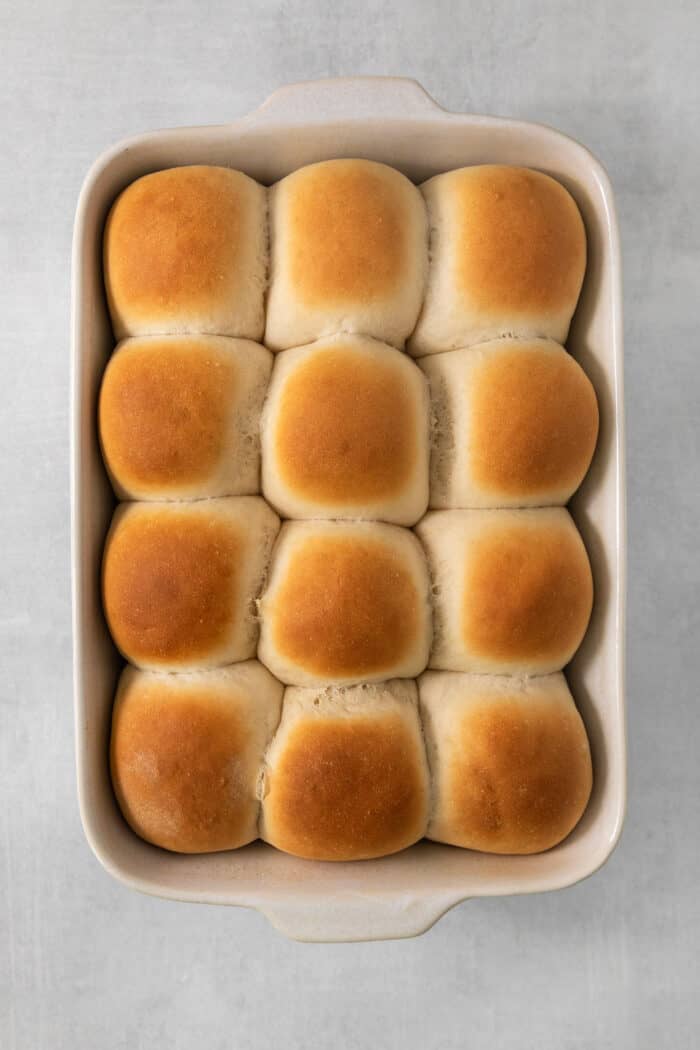 These copycat Rhodes Rolls are light and fluffy with a tender crumb and delicate flavor. Perfect for holiday meals! A baking pan of baked rhodes rolls.