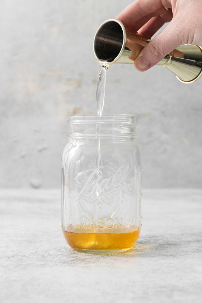 This Salted Nut Roll Shot is a fantastic twist on the salted nut roll candy bar with Rumchata, peanut butter whiskey, and vanilla vodka. Vodka is poured into a mason jar.