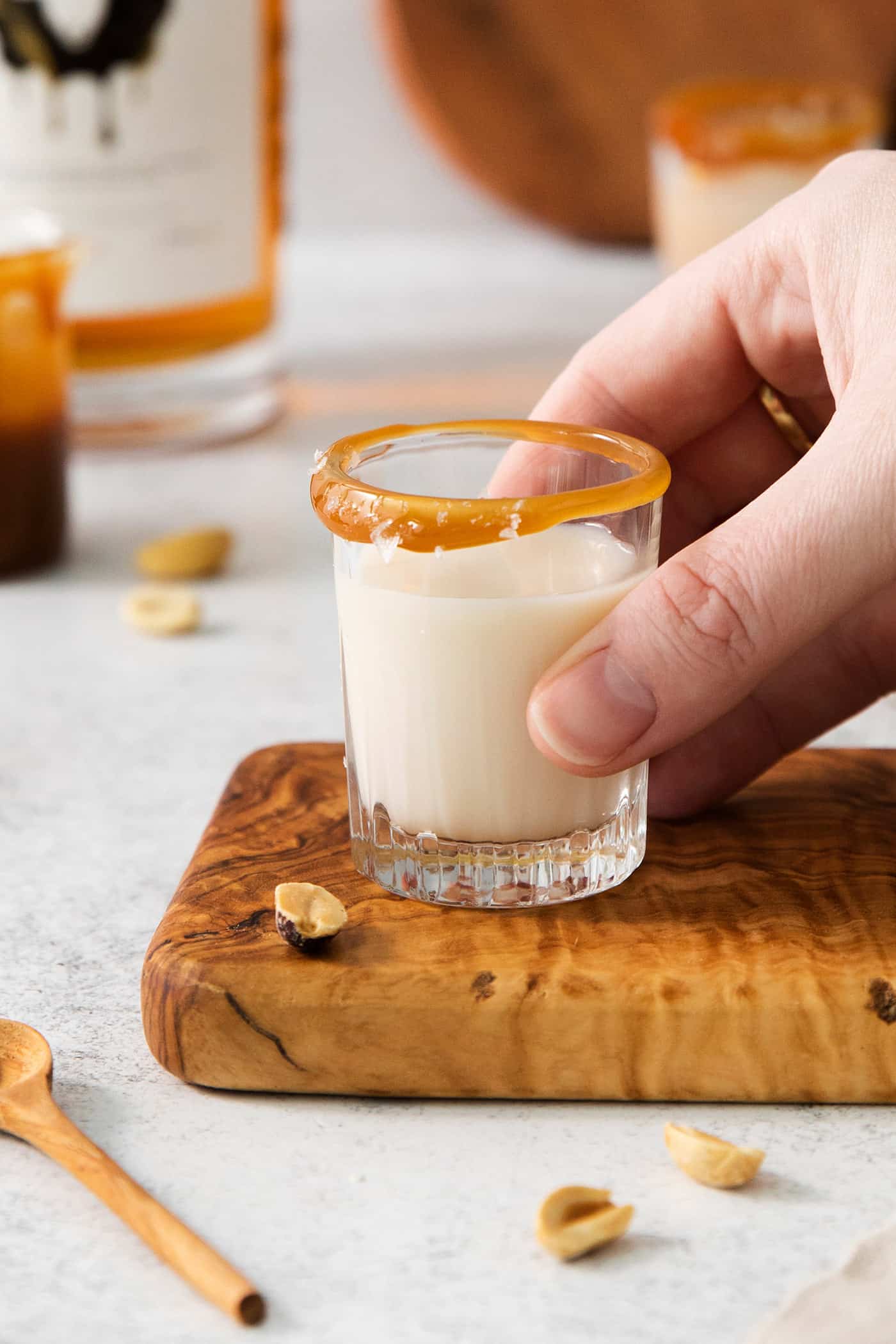 A hand holds a salted nut roll shot.