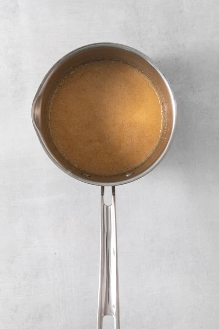 Sweet and pillowy Caramel Rolls make any morning special! Yeast dough and homemade caramel sauce make the ultimate breakfast treat. A metal pot holds caramel sauce.