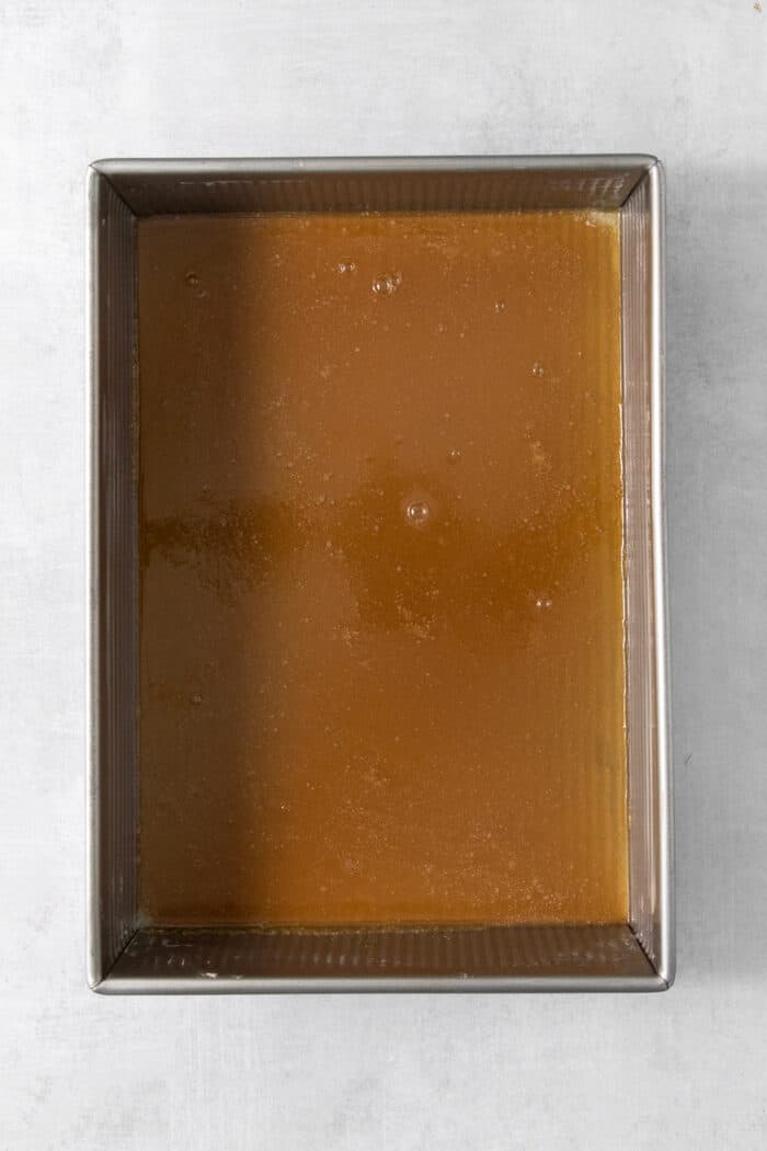 Sweet and pillowy Caramel Rolls make any morning special! Yeast dough and homemade caramel sauce make the ultimate breakfast treat. Caramel sauce is spread on the bottom of a rectangular metal baking dish.