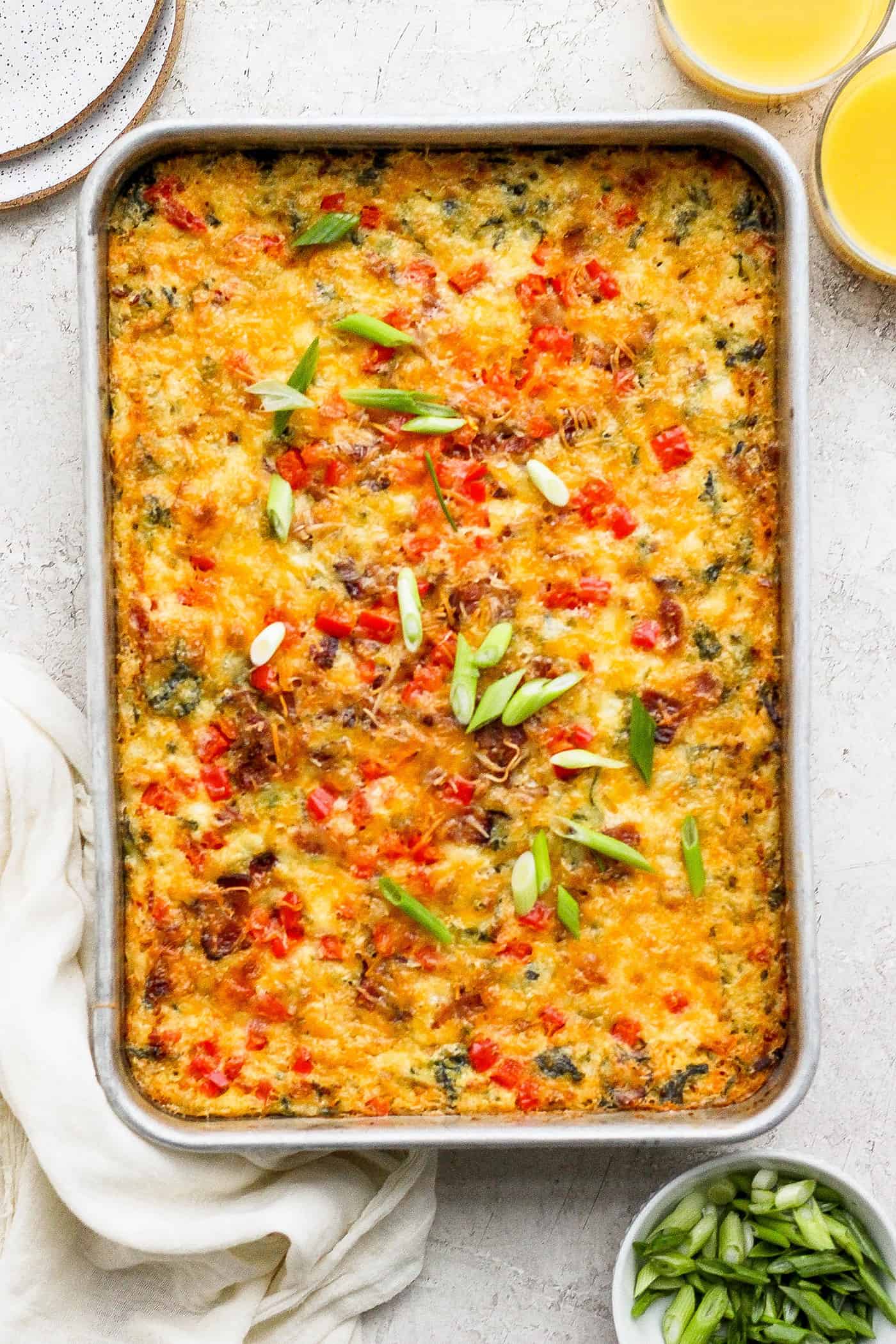 This protein-packed cottage cheese egg bake recipe combines creamy, fluffy eggs and cottage cheese with colorful veggies and crispy bacon. A baked pan of cottage cheese egg bake.