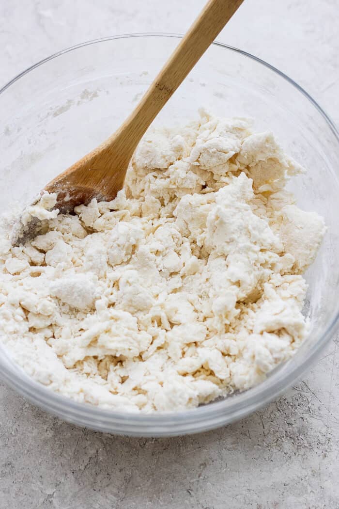 Rich, tender Cream Biscuits need just 3 simple ingredients and 15 minutes to make! Serve them with brunch or a hot bowl of homemade soup. A wooden spoon mixes up cream biscuit dough in a glass bowl.