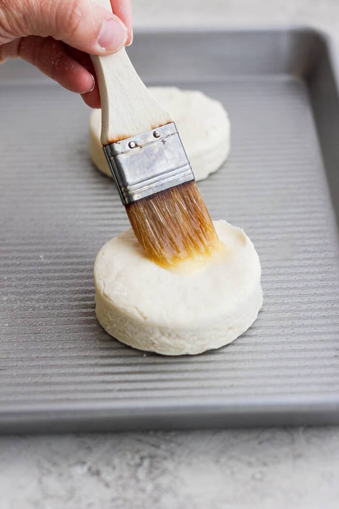 Rich, tender Cream Biscuits need just 3 simple ingredients and 15 minutes to make! Serve them with brunch or a hot bowl of homemade soup. A hand uses a pastry brush to brush the top of a cream biscuit before it's baked.