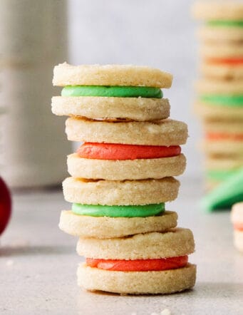 A stack of cream wafter cookies with red and green filling.