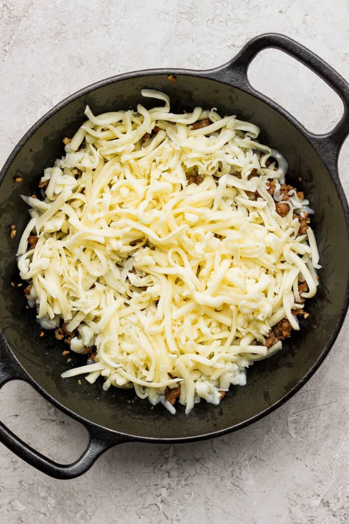 Creamy and just a little spicy, Queso Fundido is an easy, go-to dip! Melted cheese and chorizo are topped with fresh tomatoes and jalapeno. Shredded Jack cheese is layered on top of Oaxaca cheese and chorizo in a cast iron skillet.