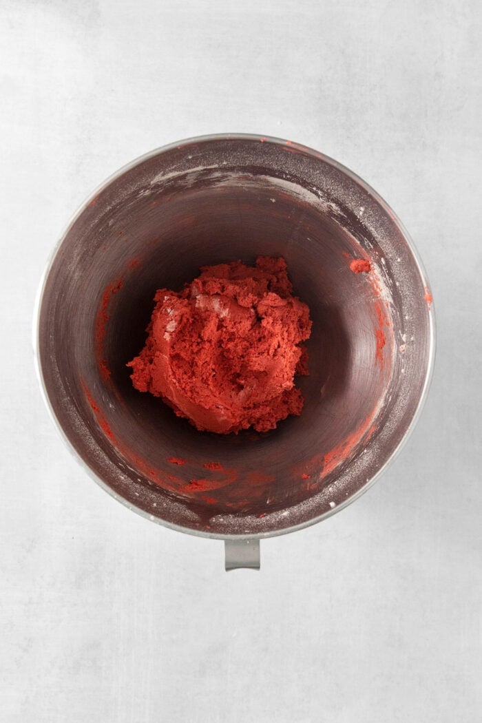 These Red Velvet Cookies are soft and chewy, with a crisp sugar coating and a hint of cocoa and vanilla for flavor. A top down shot of a metal bowl of red velvet cookie dough.