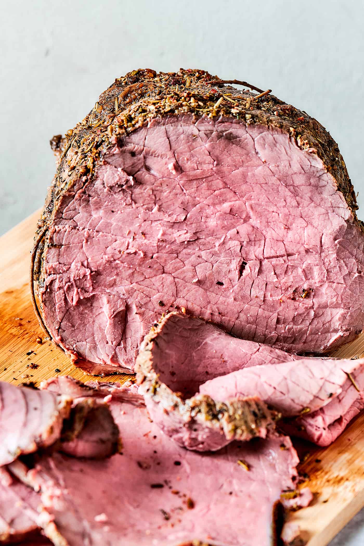 roast beef on a wood cutting boards, with some of it sliced