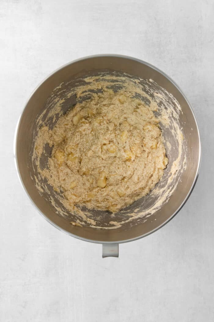 This Banana Coffee Cake features a tender banana bread cake layered with an oat streusel and topped with an optional vanilla bean glaze. A metal bowl of banana coffee cake batter.